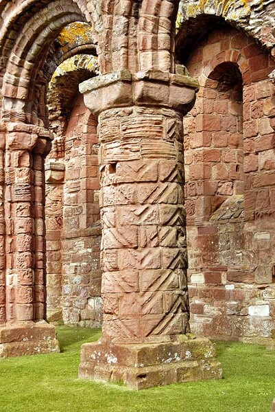 A pillar at Lindisfarne Priory, showing the chevron or zigzag design, which is also seen on the pillars of Durham Cathedral. As the priory was built by the Durham-based community of St. Cuthbert after the construction of the cathedral, it is likely that the same masons worked on both buildings, hence explaining the similarities. 
