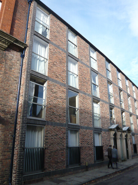 Bailey House was built in 1970 as student accommodation for Hatfield College. The facade is clearly modern, but its windows mirror the rhythm and proportions of buildings from the 18th and 19th centuries. In addition, the subtle differences in colour of the bricks on the facade is totally in keeping with the appearance of older buildings, and the two stone doorways are re-used. Seen in this photo, the facade may not seem particularly attractive, but in fact it blends in very well with the older buildings along the street. It is easy to walk by and not notice that this is a modern building, and in that respect Bailey House is a successful intervention in a historic environment.  Although almost contemporary with the Jevons Building seen in the previous images, the way it responds to the older buildings of North Bailey is completely different.