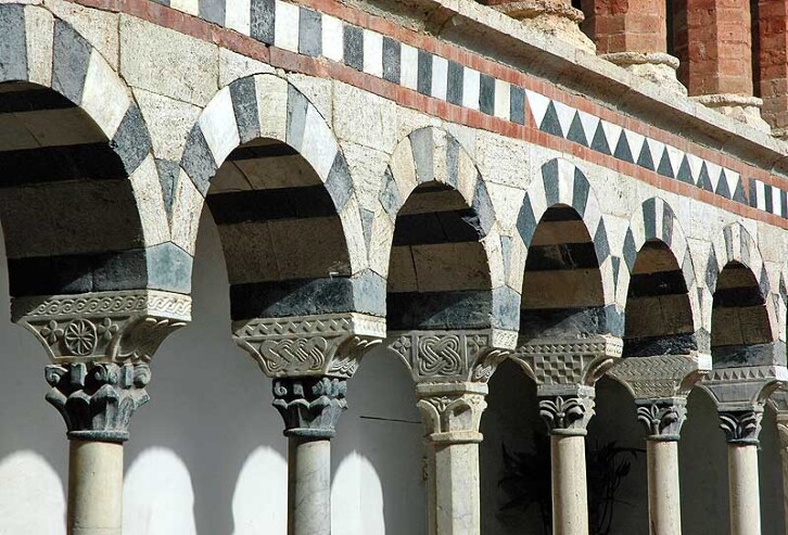 Detail of the arcading in the cloister, Church of the Holy Trinity, Torri, Tuscany, 13th century. The use of different materials to create contrast, and the reliance on geometric patterns and interlocking designs was common to both Romanesque and Islamic architecture. Note the checkerboard effect on the third column from the right. The deep carving creates areas of light and shadow that create striking patterns using a very simple pattern. 