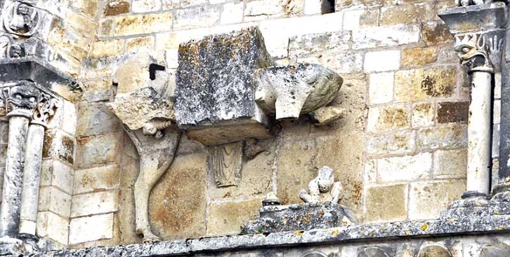 Detail of the exterior stonework of the church of St Nicholas, Civray, France, 12th century. The two faces on the columns are perhaps among the closest parallels to the Durham Cathedral's sanctuary knocker. 