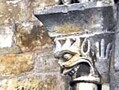 Detail of the exterior stonework of the church of St Nicholas, Civray, France, 12th century. The two faces on the columns are perhaps among the closest parallels to the Durham Cathedral's sanctuary knocker. 